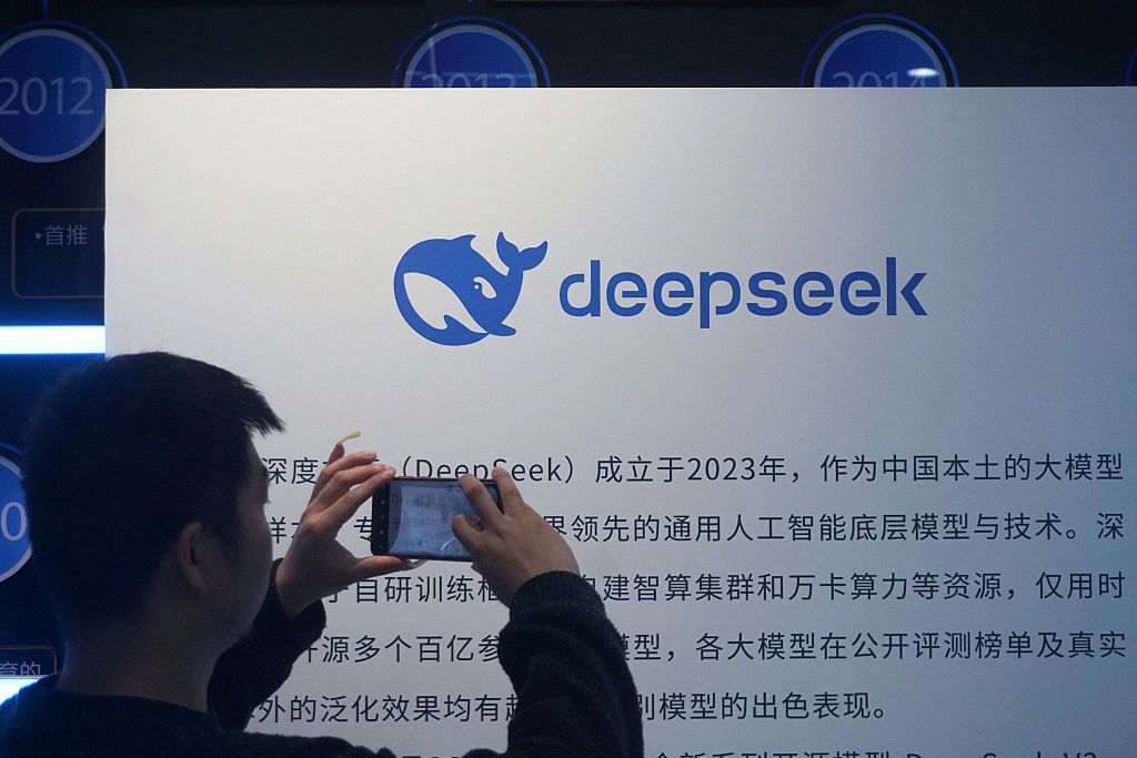 항저우의 한 쇼핑몰에 설치된 DeepSeek 전시물을 촬영하는 남성의 모습